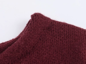 Close-up of high-quality dark red knit fabric with soft texture and refined stitching