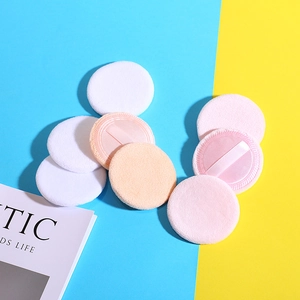 Soft cotton round powder puffs in pink, white, and beige colors on a vibrant background