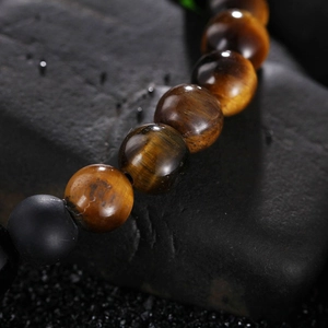 Macro detail of natural tiger eye and matte onyx beads with smooth polished texture
