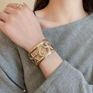 Detail of gold starfish and shell open cuff bracelet and matching spiral ring on model
