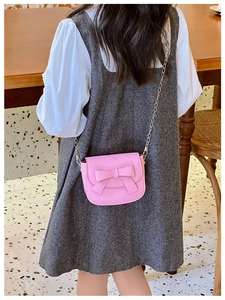 Pink girls crossbody bag with cute bow decoration and gold chain strap detail