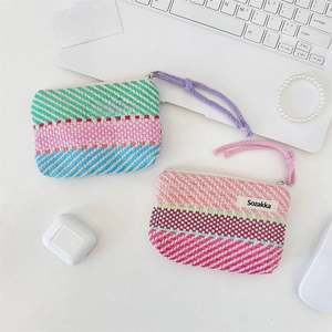 Close-up of hand-woven striped cosmetic bag with durable metal zipper and logo label