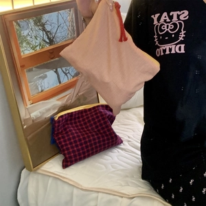 Detail of pink and white checkered cotton makeup bag with handle for travel storage