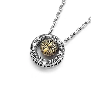 Detail of Mobius bead pendant with gold inner sphere and engraved silver patterns