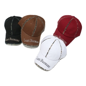 Detail view of frayed edges, leopard print paneling, and embroidery on baseball caps