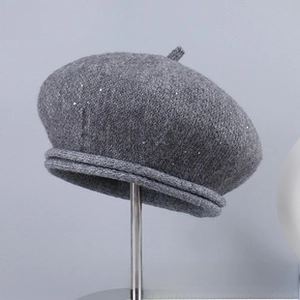 Detailed close-up of a grey wool beret featuring subtle silver sequins and knitted texture