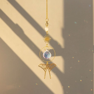 Macro detail of brass butterfly crystal suncatcher showing light refraction and shadows