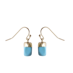 Detail view of light blue natural stone earrings with polished gold hooks on white background