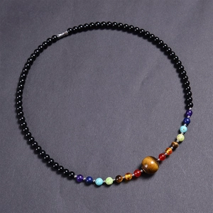 Detail of 6mm black bead necklace featuring colorful natural stones and tiger eye pendant