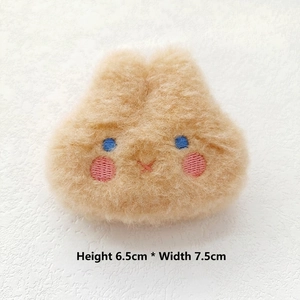 Detailed plush animal head badge in khaki with 6.5cm by 7.5cm dimensions display
