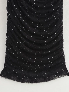 Détail de tissu noir plissé avec strass argentés et bordure en dentelle cil délicate