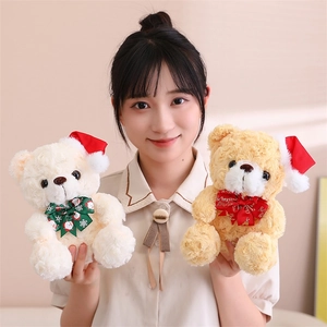 Smiling model holding beige and light brown Christmas teddy bears with holiday bows