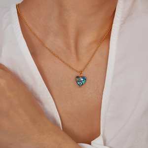 Golden bead chain necklace with heart-shaped colorful abalone shell pendant on model