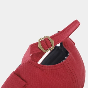 Detail of adjustable strap with bronze buckle on a red canvas docker hat