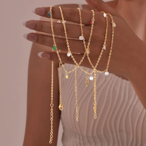 Layered gold stainless steel necklace with colorful zircon pendants held by a hand