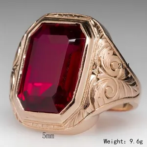 Vintage men's gold ring with a large rectangular red gemstone and ornate engraving