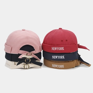 Detail of adjustable metal buckles and NEW YORK embroidery on cotton brimless docker caps