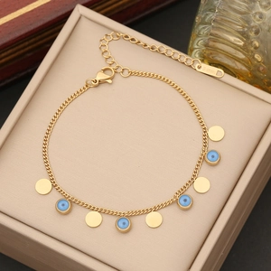 Goldenes Edelstahl-Armband mit blauen bösen Augen und Herzanhängern auf Schmuckschatulle
