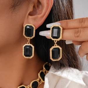 Vue détaillée des boucles d'oreilles vintage dorées avec cristaux noirs octogonaux