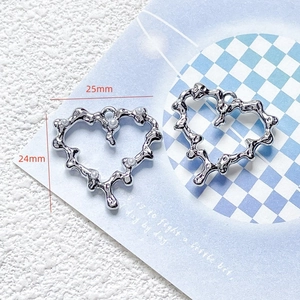 Macro view of silver alloy heart pendants with dimensions 25mm by 24mm and pearl detail