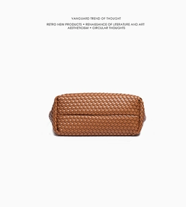 Detailed bottom view of large caramel woven tote bag with premium leather texture