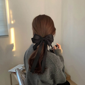 French style large black satin bow hair clip with long ribbons worn on the back of head