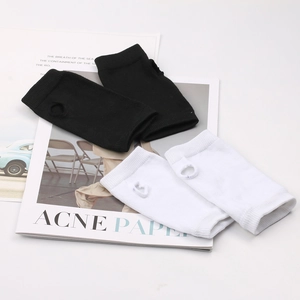 Détail de mitaines en tricot noir et blanc avec passage de pouce posées sur un magazine
