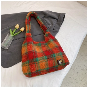 Detail of plaid fleece tote bag showing colorful checkered pattern and fuzzy texture