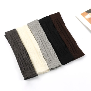 Detail view of five colors of cable knit leg warmers in a flat lay arrangement