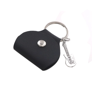 Detail of black leather guitar pick pouch featuring a silver snap and metal guitar charm