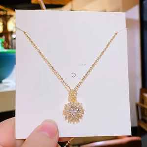 Luxurious sunflower zircon necklace with gold chain shown on a delicate brand card