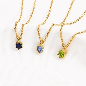Detailed macro view of 18K gold plated necklaces with blue and green zircon heart pendants