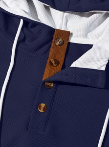 Détail d'un sweat à capuche bleu marine avec patte à quatre boutons et doublure mesh