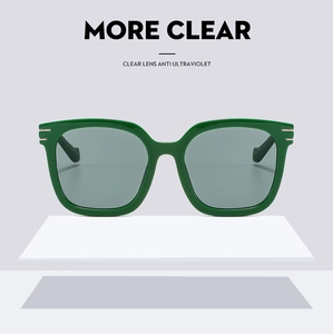 Detail of green oversized square sunglasses with metal hinge accents and UV protection lenses
