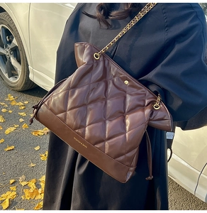 Close-up of brown quilted bucket bag with gold chain strap and Fashion & Bags text