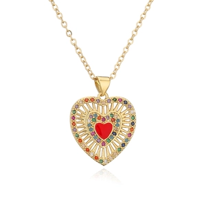 Gold heart pendant necklace with red stone and colorful crystals on white background