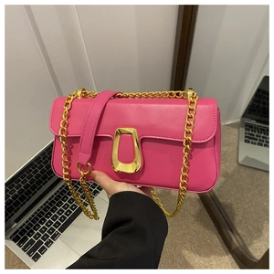 Detail of pink PU leather handbag showing golden metal lock and chain strap