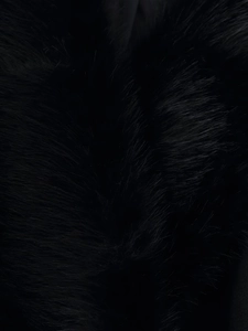 Détail de la texture de fourrure synthétique noire sur l'élégant manteau d'hiver