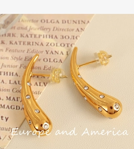 Macro detail of 18K gold plated teardrop earrings with sparkling white rhinestones