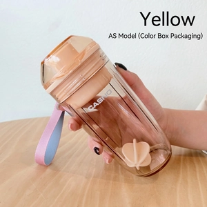 Détail d'un shaker jaune avec boule de mélange et sangle de transport tissée chic