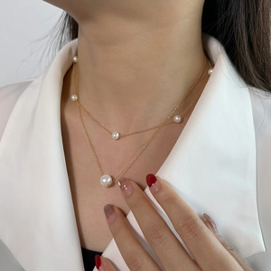 Double-layered S925 silver pearl necklace with gold chain on model in white blazer