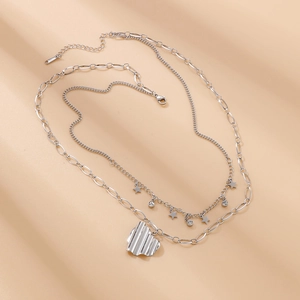Vue détaillée du collier double épaisseur en acier inoxydable avec cœur et étoiles
