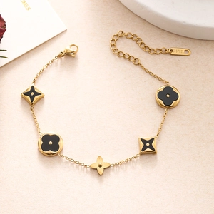 Detailed macro view of gold-plated stainless steel double chain bracelet with black charms