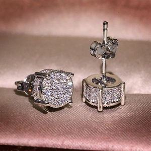 Macro shot of silver round cz stud earrings with pave setting on satin background
