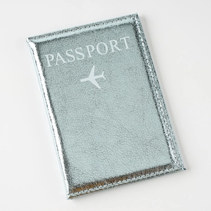 Macro detail of silver-blue metallic leather passport cover with white embossed text