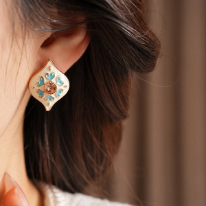 Vintage gold-tone diamond earring with beige enamel and blue floral pattern details