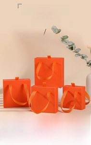 Orange drawer jewelry boxes in three sizes with ribbon handles and premium paper finish