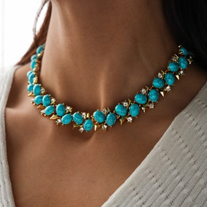 Detail of vintage turquoise gemstone statement necklace with gold settings and crystals