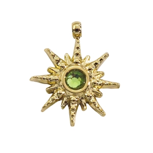 Golden sunburst star pendant with green zircon center on white background