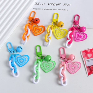 Colorful heart-shaped keychains with bells and chains in multiple vibrant candy colors